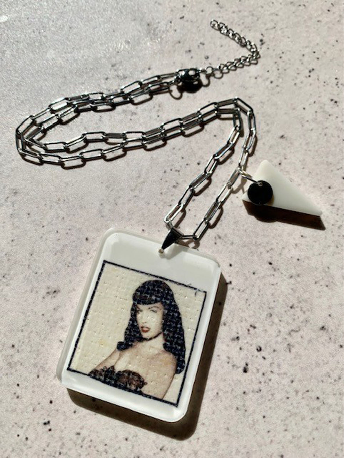 necklace with hand crafted ivory resin pendant with vintage bettie page portrait encased