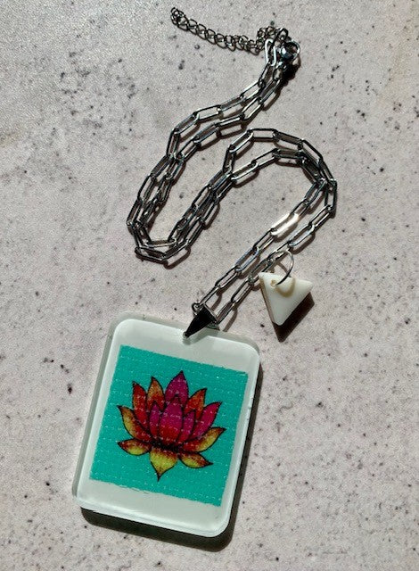 necklace with hand crafted ivory resin pendant with lotus flower artwork embedded